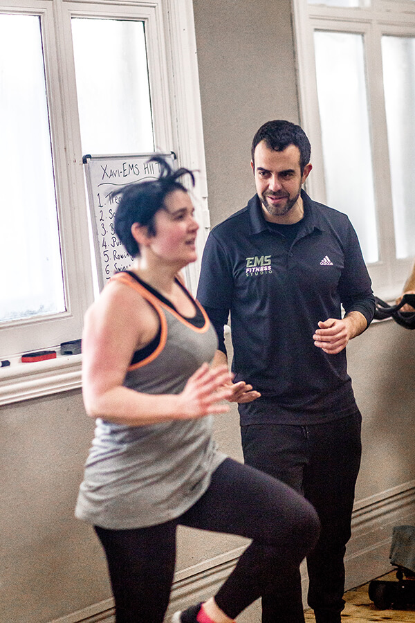 a trainer at ems fitness working with a client